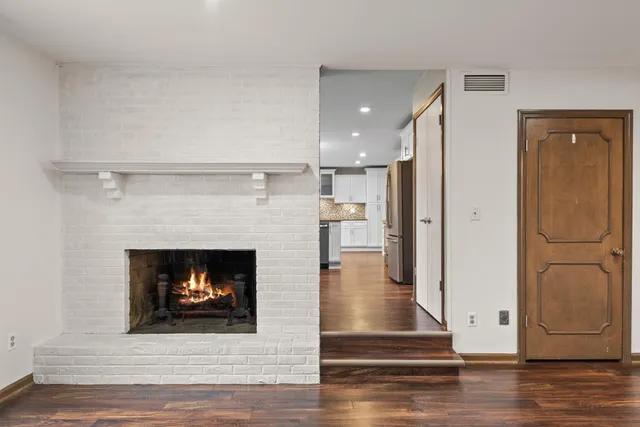a living room with wooden floor and a fireplace
