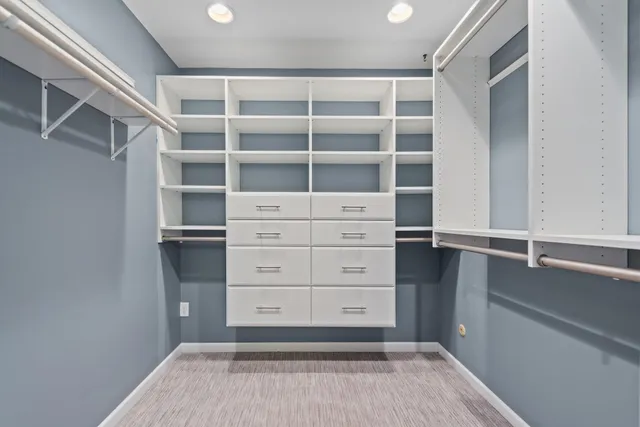 a view of walk in closet with empty racks