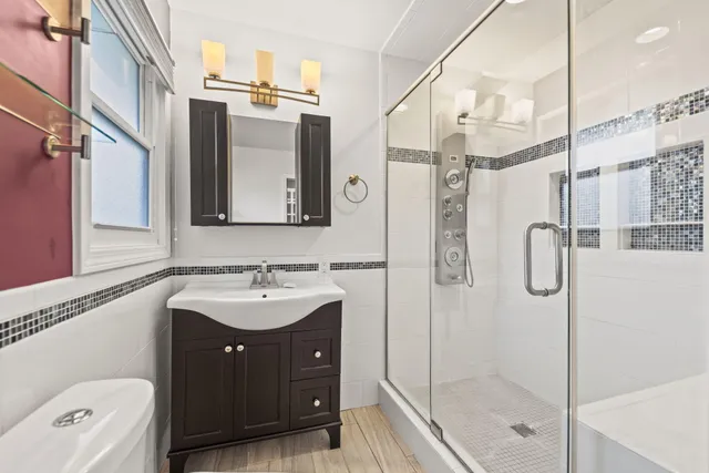 a bathroom with a sink a toilet and shower