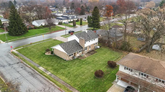 an aerial view of a house with garden space and street view