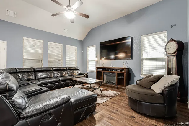 a living room with furniture a fireplace and a flat screen tv