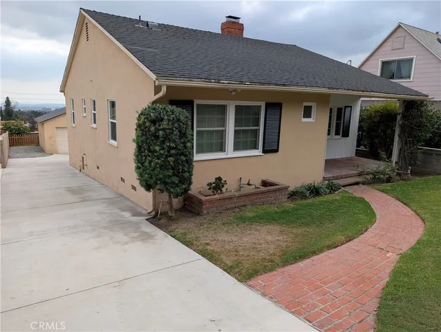 a front view of a house with a garden