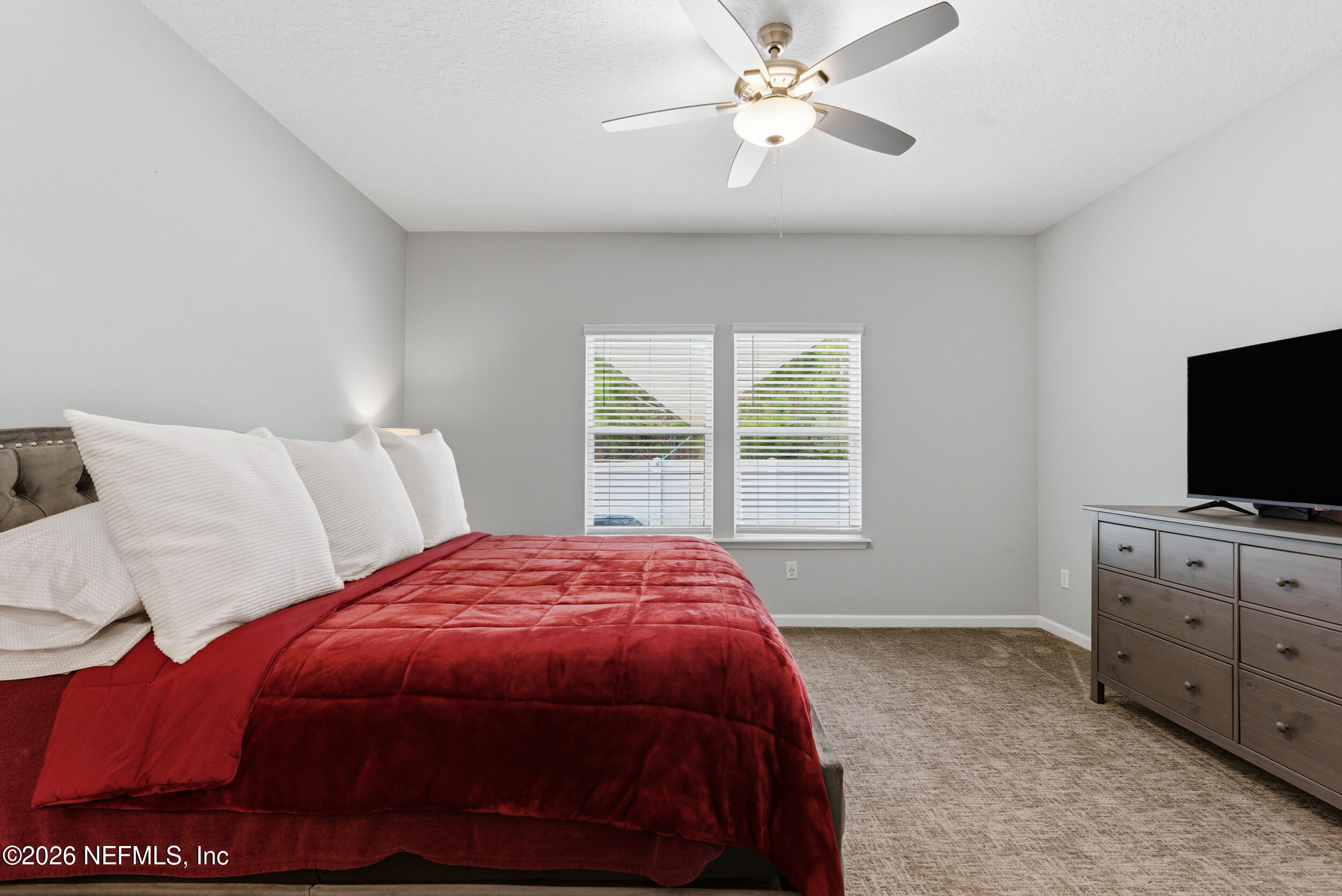 6507 Longleaf Branch Drive Jacksonville, FL 32222 - Photo 20 of 34 a spacious bedroom with a bed and a flat screen tv
