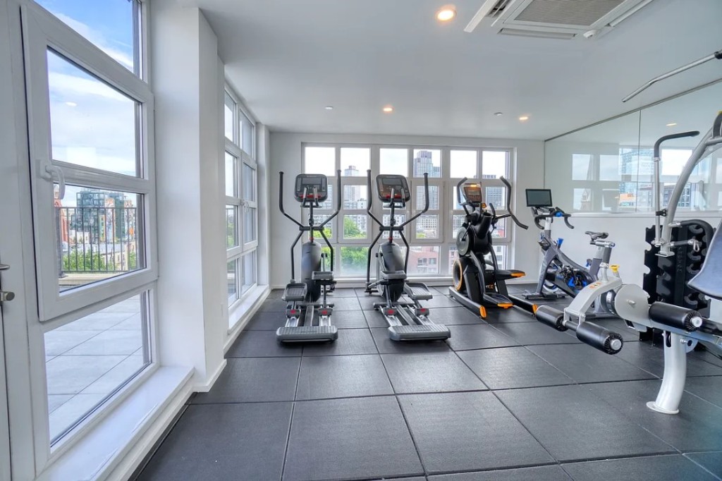 5-33 48th Avenue, Unit 4G Queens, NY 11101 - Photo 10 of 13 a view of a room with gym equipment and floor to ceiling window