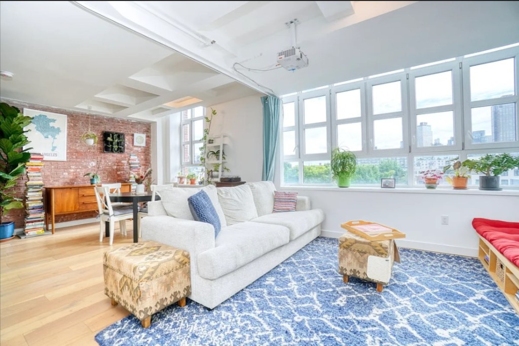 5-33 48th Avenue, Unit 4G Queens, NY 11101 - Photo 1 of 13 a living room with furniture and a table