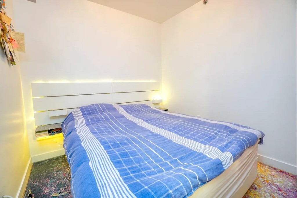 5-33 48th Avenue, Unit 4G Queens, NY 11101 - Photo 6 of 13 a bed sitting in a bedroom next to a window