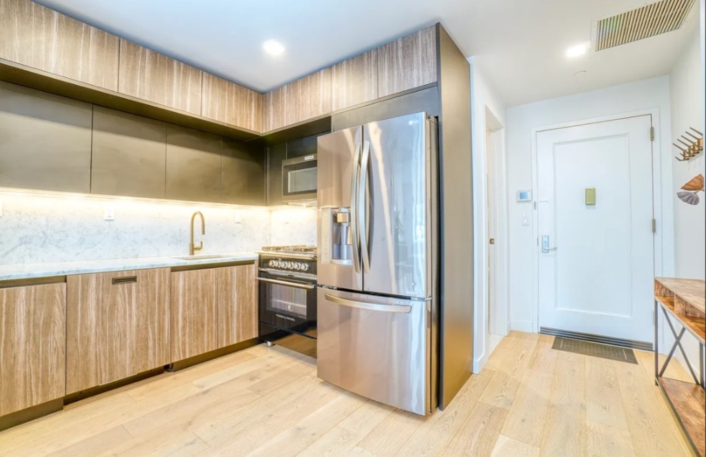 5-33 48th Avenue, Unit 4G Queens, NY 11101 - Photo 8 of 13 a kitchen with stainless steel appliances granite countertop a refrigerator and a sink