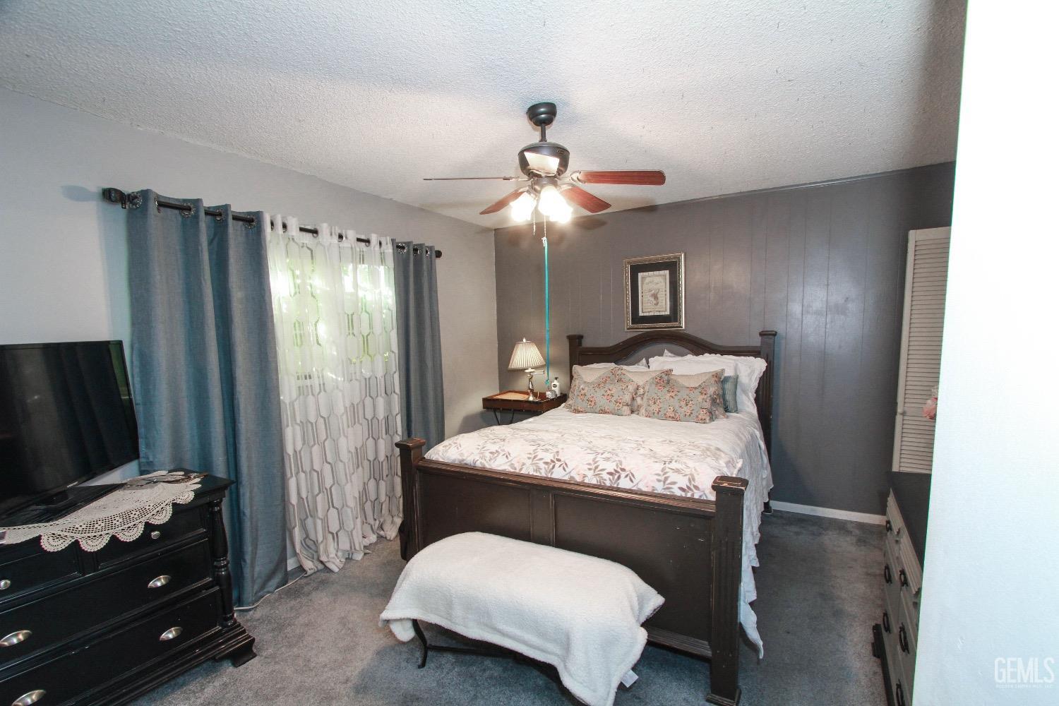 Undisclosed Address Bakersfield, CA 93306 - Photo 14 of 19 a bedroom with a bed and a flat tv screen on a dresser