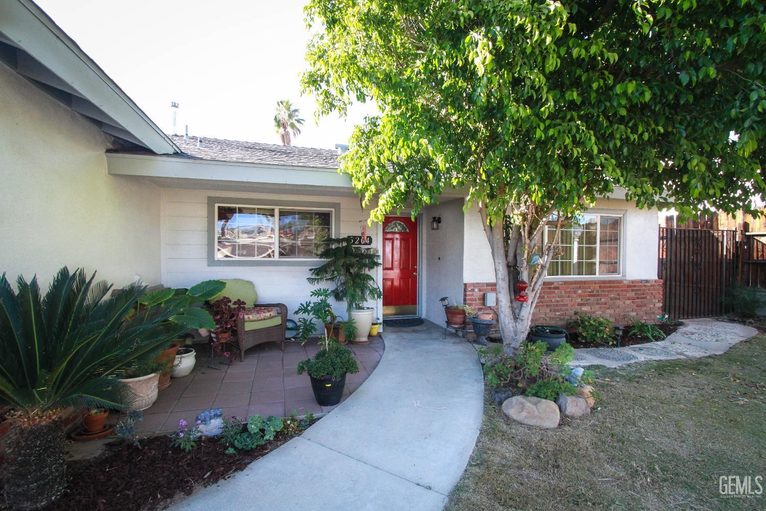 Undisclosed Address Bakersfield, CA 93306 - Photo 2 of 19 a front view of a house with potted plants and a bench