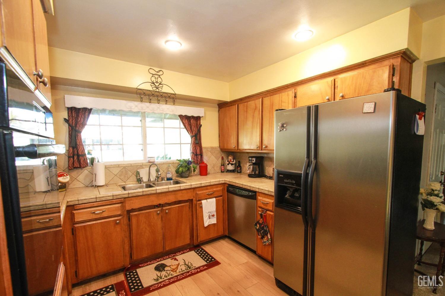 Undisclosed Address Bakersfield, CA 93306 - Photo 7 of 19 a kitchen with stainless steel appliances granite countertop a refrigerator a sink dishwasher with a dining table and chairs