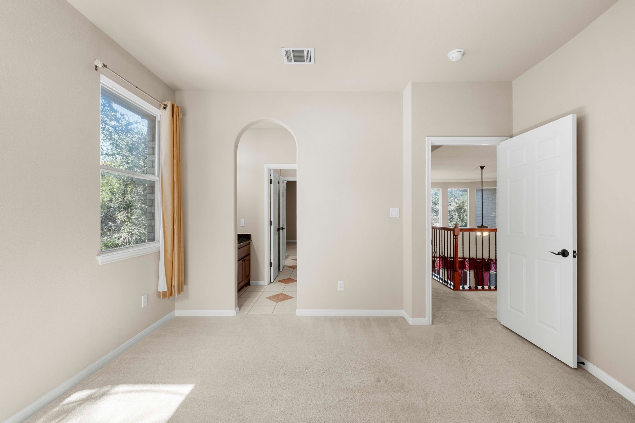 3903 Remington Road Cedar Park, TX 78613 - Photo 20 of 29 A quiet secondary room offers plush carpeting and an arched entry leading to additional living spaces.