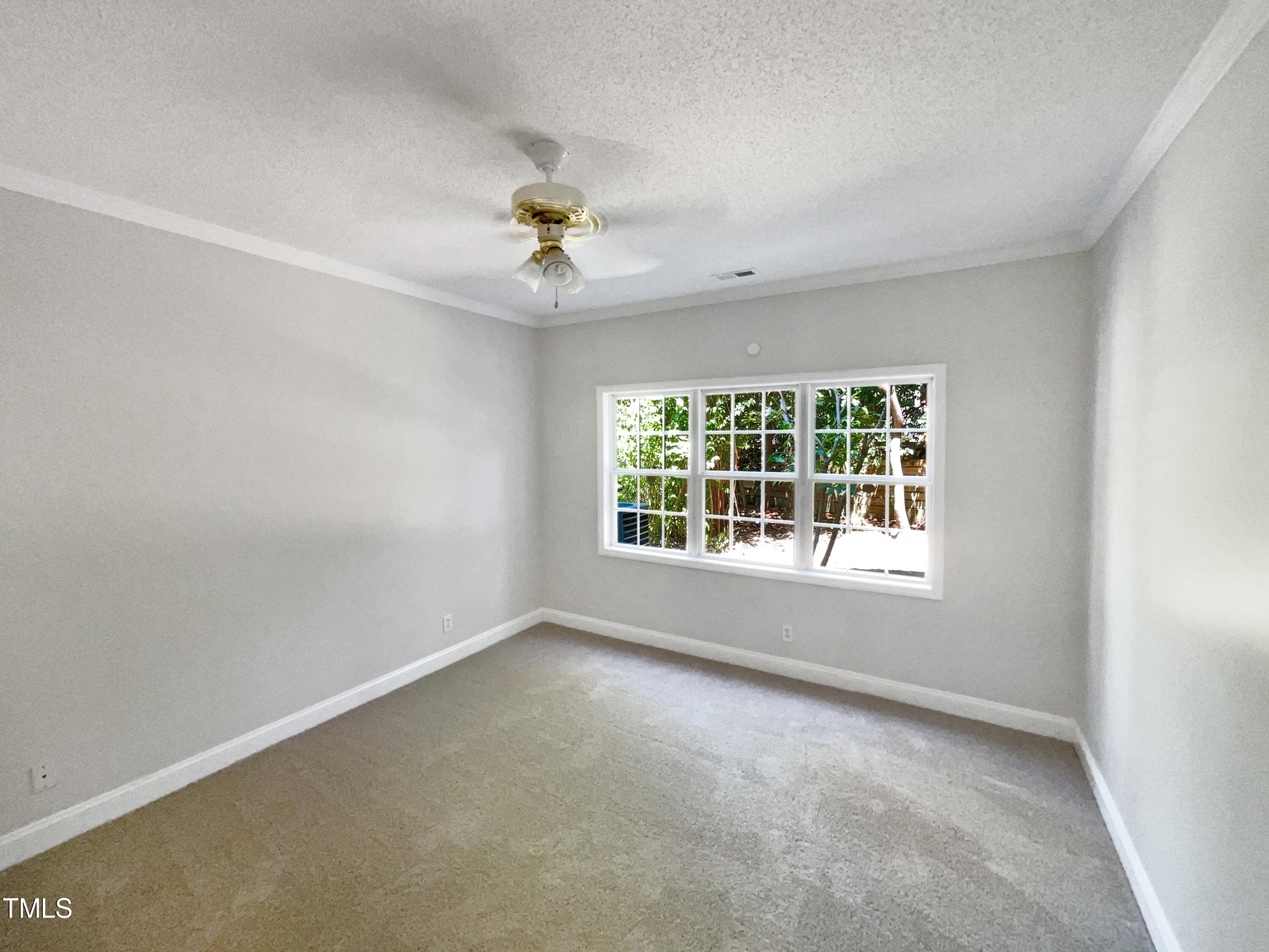 4117 Beaufain Street Raleigh, NC 27604 - Photo 7 of 24 an empty room with a window and a fan