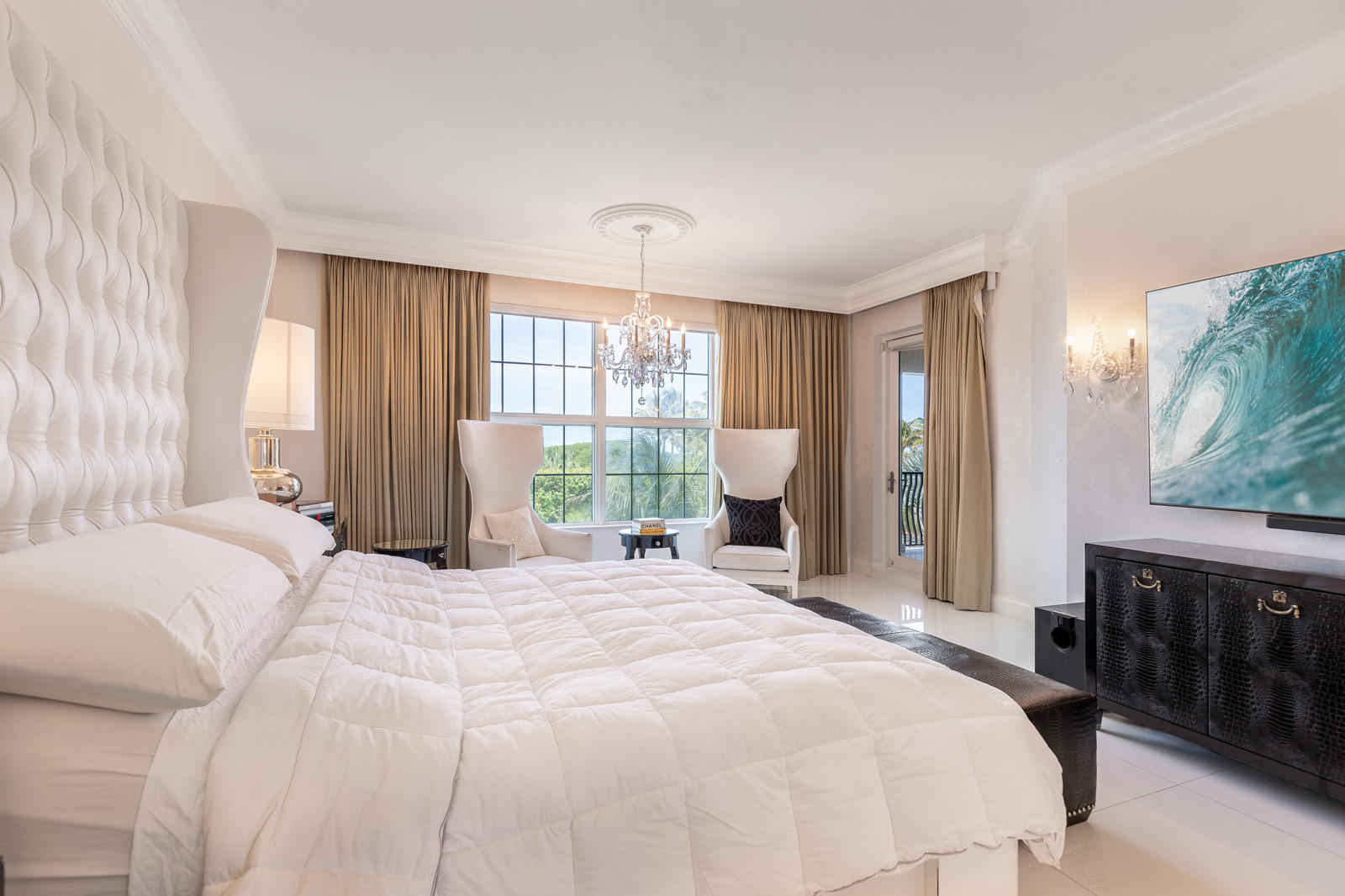 1 North Ocean Boulevard, Unit 305 Boca Raton, FL 33432 - Photo 13 of 27 a spacious bedroom with a bed a dresser a chandelier and a window