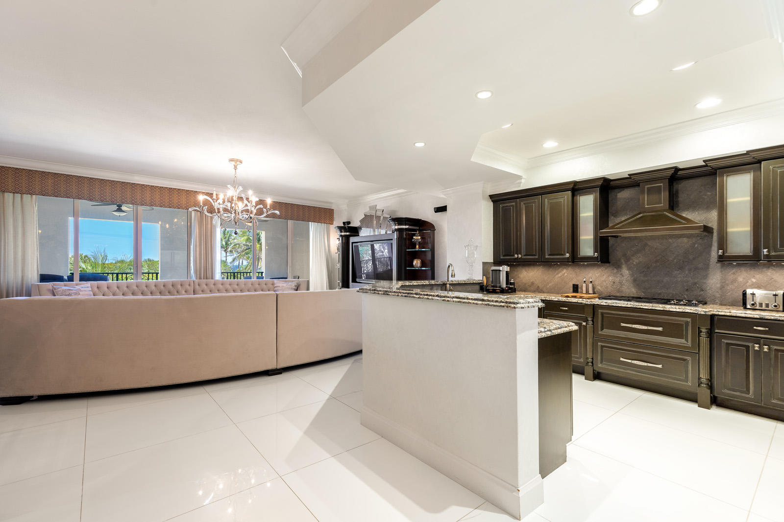 1 North Ocean Boulevard, Unit 305 Boca Raton, FL 33432 - Photo 6 of 27 a large kitchen with kitchen island granite countertop a stove a sink a refrigerator and a microwave