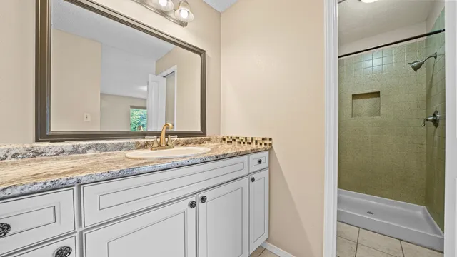a bathroom with a granite countertop sink and a mirror