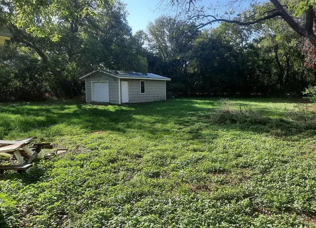 a view of a barn in the middle of a yard