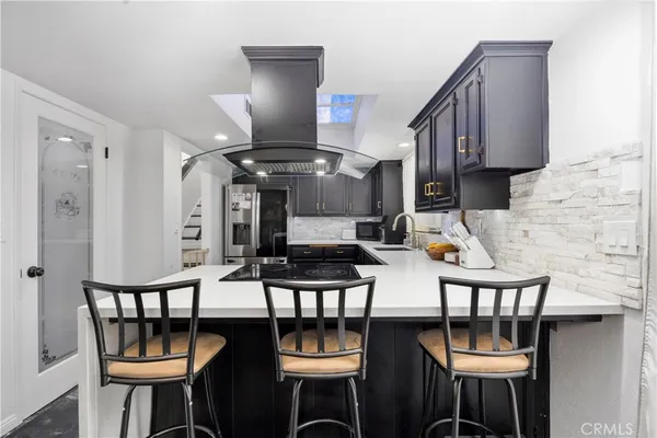 a kitchen with granite countertop a sink stainless steel appliances and cabinets
