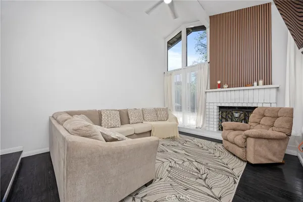 a living room with furniture a fireplace and a flat screen tv
