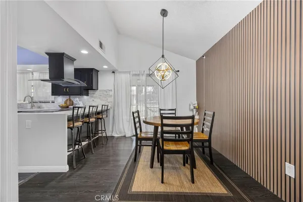 a kitchen with stainless steel appliances a table chairs and a refrigerator