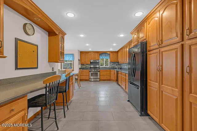 a kitchen with stainless steel appliances granite countertop a refrigerator and a stove top oven