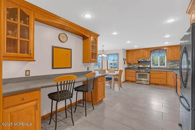 a kitchen with stainless steel appliances granite countertop a sink and a refrigerator