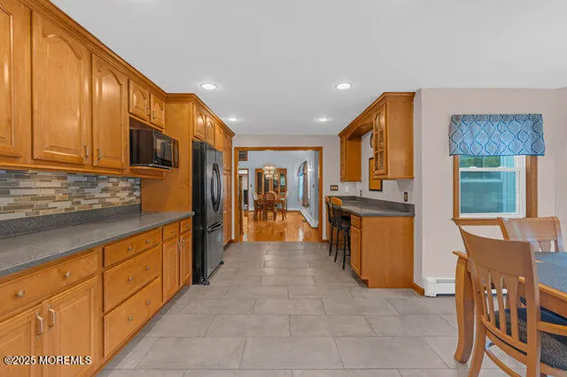 a large kitchen with stainless steel appliances granite countertop a refrigerator and a stove top oven
