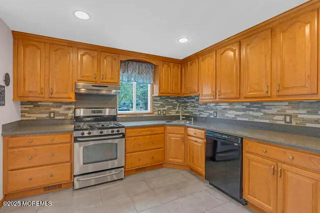 a kitchen with stainless steel appliances granite countertop a stove sink and cabinets