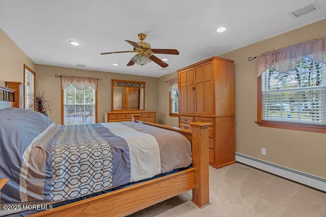 a bed sitting in a spacious bedroom next to a window