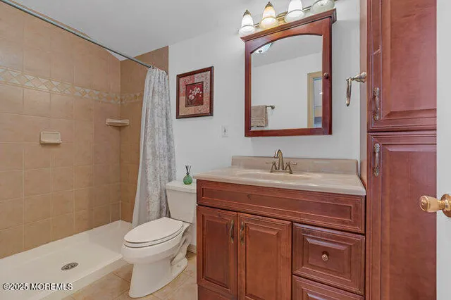 a bathroom with a granite countertop toilet sink and mirror