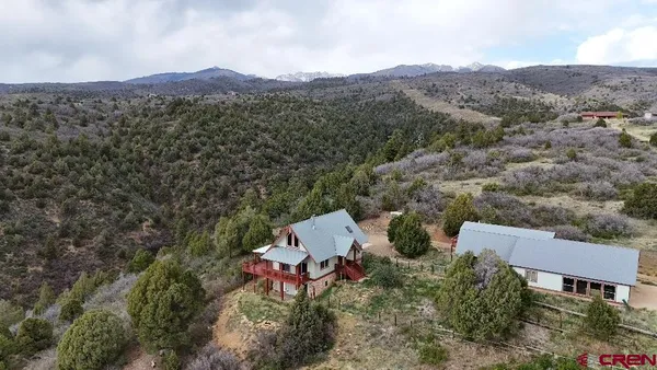 an aerial view of a house with a mountain
