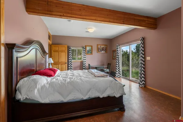 a bedroom with a bed and large windows