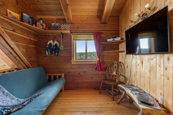 a view of a room with wooden floor and furniture