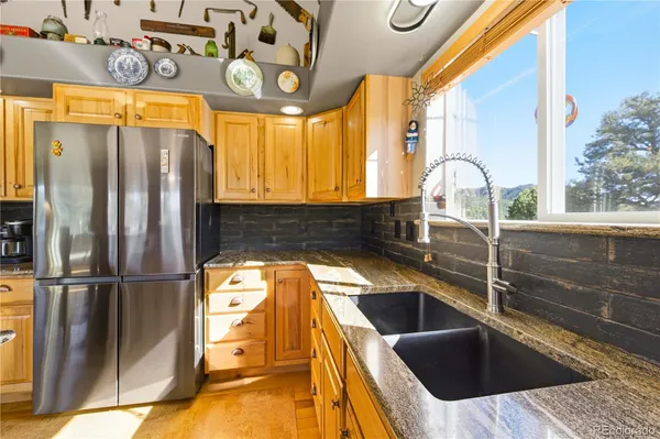 a kitchen with stainless steel appliances granite countertop a sink a refrigerator and window