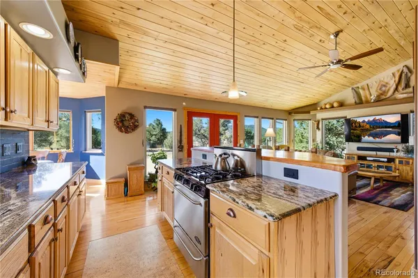 a kitchen with stainless steel appliances granite countertop a stove and a wooden cabinets