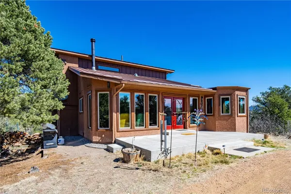 a view of a house with a yard patio and a tree