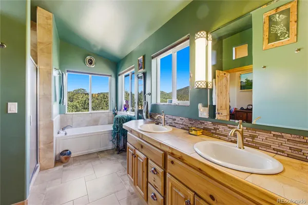 a bathroom with a granite countertop tub sink a mirror and a bathtub