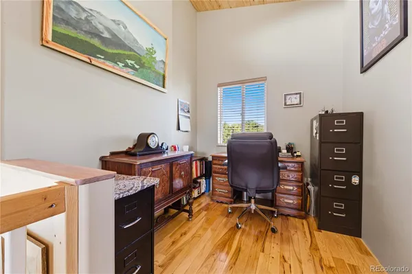 a view of a workspace with furniture and wooden floor