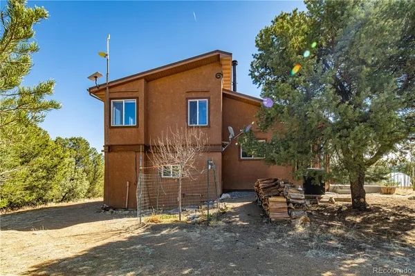 a view of a house with backyard and a tree