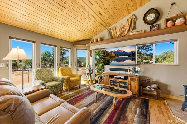 a living room with furniture a flat screen tv and a floor to ceiling window
