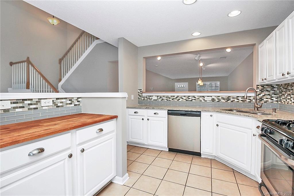 16736 Timber Crossing Road Charlotte, NC 28213 - Photo 14 of 33 a kitchen with granite countertop white cabinets and white appliances