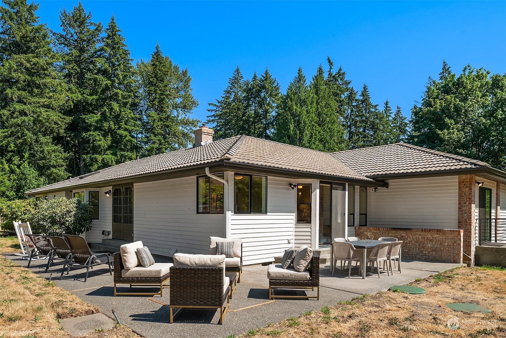 16254 Southeast 144th Street Renton, WA 98059 - Photo 23 of 29 a view of a patio with couches table and chairs under an umbrella