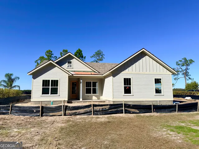 a view of a house with a yard and lawn chairs