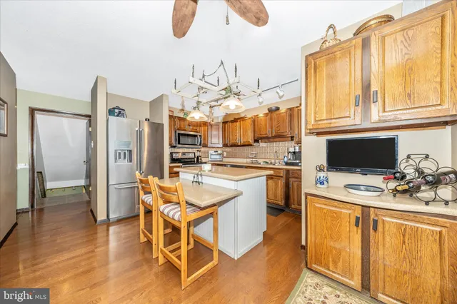 a kitchen with stainless steel appliances kitchen island granite countertop a refrigerator and microwave