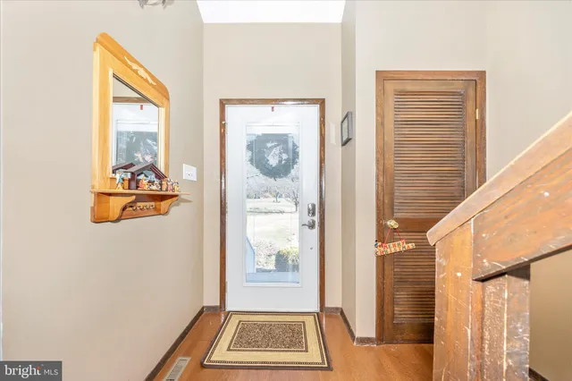 a view of a hallway with a door and wooden floor