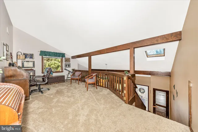 a view of a workspace with furniture and a window