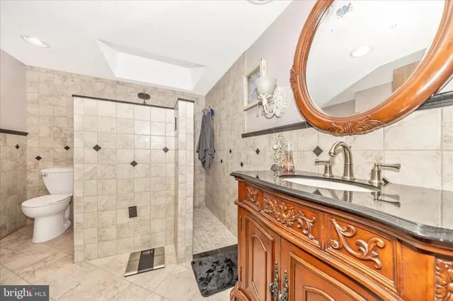 a bathroom with a granite countertop sink a toilet and shower