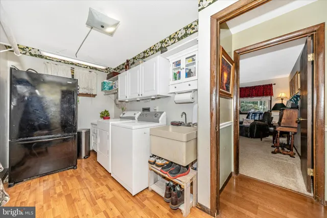 a view of swimming pool with lawn chairs and large trees