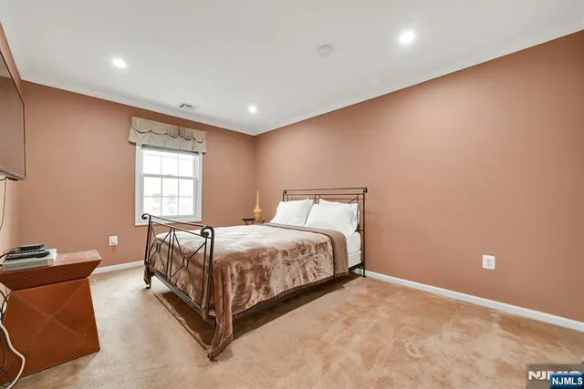 a bed sitting in a spacious room next to a window