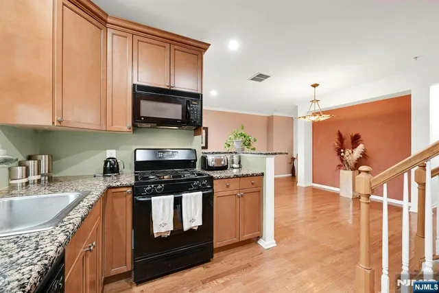 a kitchen with stainless steel appliances granite countertop a stove a sink and a microwave