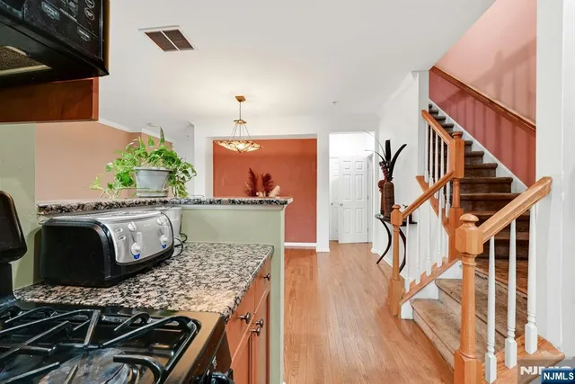 a kitchen with granite countertop a stove and a wooden floor
